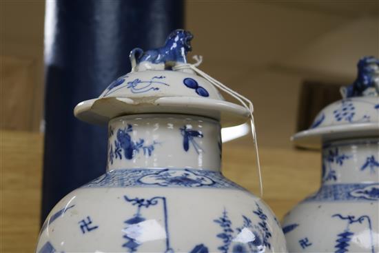 A pair of 19th century Chinese blue and white baluster vases and covers, decorated with figures, 37cm